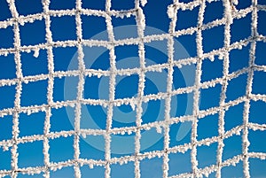 The football goal net, covered with hoarfrost