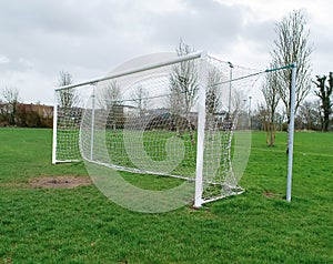 Football goal post on a training ground. Worn out grass on a keeper spot. Soccer theme background