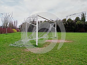 Football goal post on a training ground. Worn out grass on a keeper spot. Soccer theme background