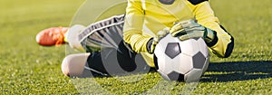 Football Goalkeeper Catching Ball. Young Boy Jumping Towards Soccer Ball and Saving Goal