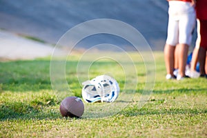Football helmet and ball on the ground close the sideline
