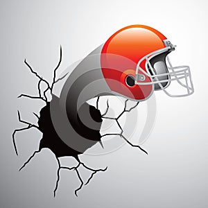 Football helmet coming out of cracked wall