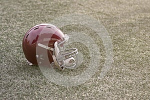 Football helmet lying on green grass field