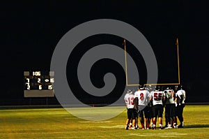 Football huddle at night game