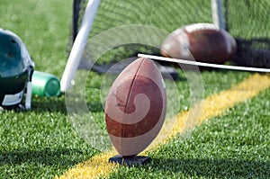 Football With Kicking Holder On Sideline Of Field