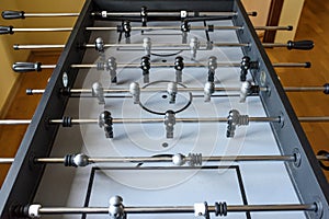 A football match of the table with black and grey players. A table game