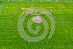 Football net on the background of a green football field. Aerial view of football gate