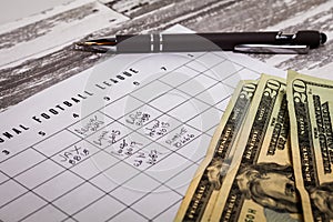 Football office pool grid for sports betting concept with cash