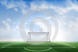 Football pitch and goal under blue sky