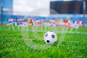 Football pitch, world nations flags, blue sky, football net in background. Sport photo, edit space