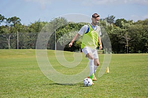 Football player dribbling the soccer on the football ground