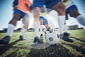 Football player, feet and men with a ball together on a field for sports game or fitness. Blurred closeup of male soccer