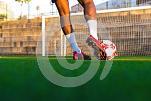 Football player feet running with the ball in front of the field. Player feet with the ball scoring a goal.