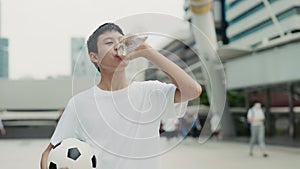 Football Player Going After Training and Drinks Water. Portrait of the Teenager Walking and Feeling Thirsty After the
