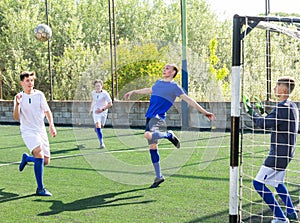 Football player hits ball with his head towards goal