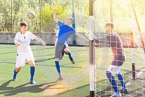 Football player hits ball with his head towards goal