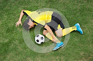 Football player lying injured on the pitch.