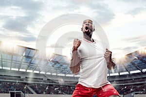 The football player in motion on the field of stadium