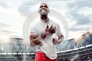 The football player in motion on the field of stadium