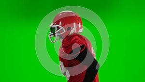 Football player running red uniform and helmet. Green screen, close up