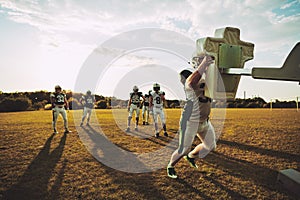 Football players doing tackling drills together on a sports fiel