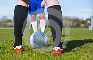 Football players facing off on pitch