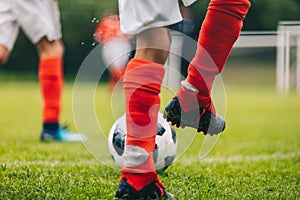 Football Players Kicking Ball on Grass Venue. Football Pitch Stadium in the Background