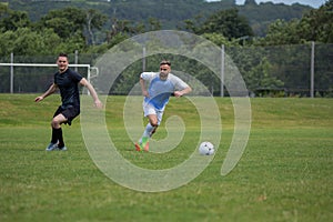 Football players playing soccer in the ground