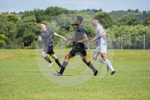 Football players playing soccer in the ground