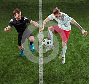 Football players tackling ball over green grass background