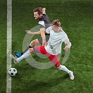 Football players tackling ball over green grass background