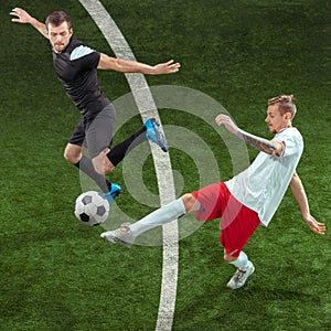 Football players tackling ball over green grass background