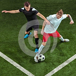 Football players tackling ball over green grass background