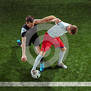 Football players tackling ball over green grass background