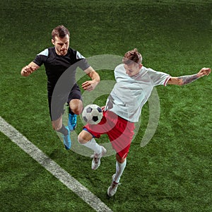 Football players tackling ball over green grass background