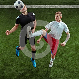 Football players tackling ball over green grass background