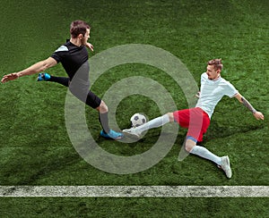 Football players tackling ball over green grass background