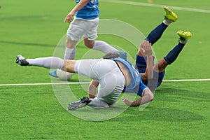 Football players tumbling on the football field. Falling players in the fight for the ball