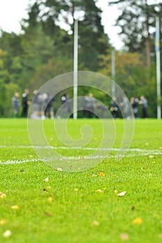 On a football practise and on a green field on a rainy, cold and grey Autumn afternoon with soccer players on a background