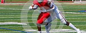 Football receiver trying to escape a tackle after catching the ball during a game