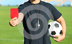 Football referee showing red card at stadium