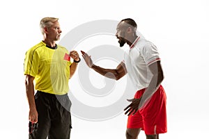 Football referee showing a red card to a displeased player isolated on white background