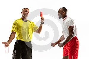 Football referee showing a red card to a displeased player isolated on white background