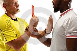 Football referee showing a red card to a displeased player isolated on white background