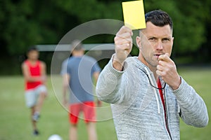 Football referee showing yellow card