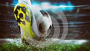 Football scene at night match with close up of a soccer shoe hitting the ball with power