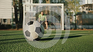 Football soccer ball against gate defended by goalkeeper