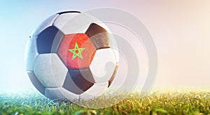 Football soccer ball with flag of Marocco on grass