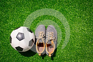 Football, Soccer ball and sport shoes on green grass