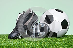 Football or Soccer boots and ball on grass